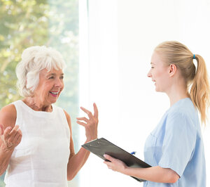 Pflegerin im Gespräch mit einer Seniorin